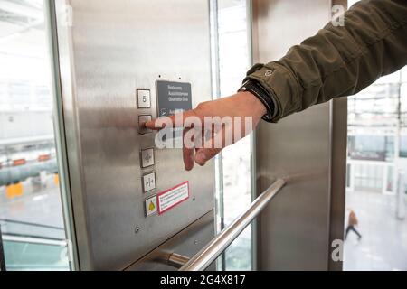 Mann drückt Taste im Aufzug Stockfoto