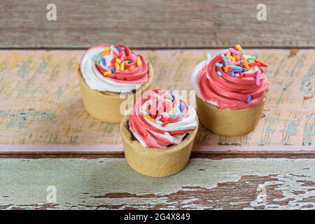 Nahaufnahme von drei Mini-Sablée-Pasteten mit Schlagsahne. Stockfoto