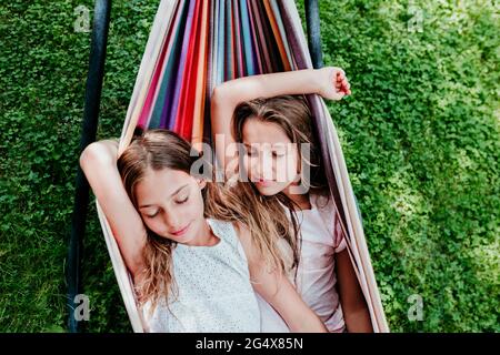 Freunde, die sich in der Hängematte im Garten ausruhen Stockfoto