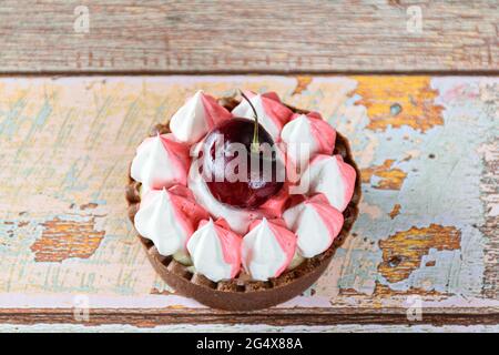 Schokoladen-Mini-Pie-Nahaufnahme mit Schokoladenganache, Schlagsahne und Kirschtoping. Stockfoto