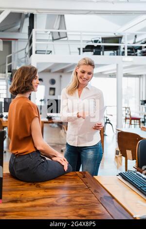 Junge Frauen diskutieren über Dokument im Kreativbüro Stockfoto