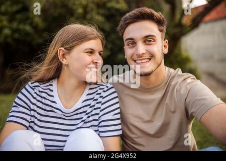 Glückliches Paar sitzt zusammen im öffentlichen Park Stockfoto