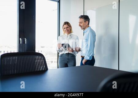 Männliche und weibliche Fachleute diskutieren über digitale Tablets im Büro Stockfoto