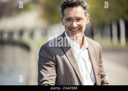 Reifer männlicher Unternehmer mit Brille lächelnd Stockfoto