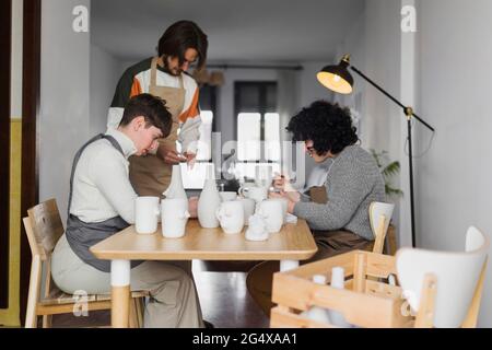 Experten malen Keramik-Geschirr am Arbeitsplatz Stockfoto