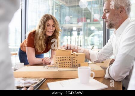 Männliche und weibliche Architekten diskutieren über Architekturmodell im Büro Stockfoto