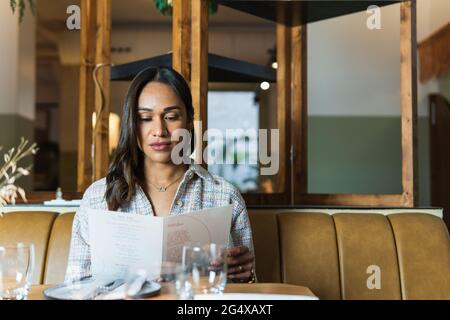 Junge Frau liest Menü im restaurant Stockfoto