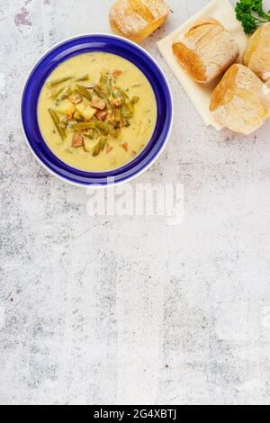 Hausgemachte Gemüsesuppe mit Brot auf blauem Teller. Stockfoto