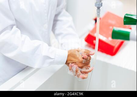 Reifer Arzt, der sich im Labor die Hände wäscht Stockfoto