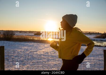 Reife Frau trägt Strickmütze läuft im Winter Stockfoto