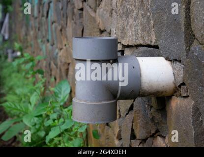 Nahaufnahme des Kanalrohrs mit dem Steindamm im Hintergrund Stockfoto