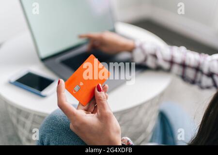 Frau mit Kreditkarte macht online einkaufen über Laptop zu Hause Stockfoto