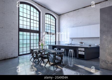 Interieur der modernen Küche mit großen Fenstern und Esstisch Stockfoto