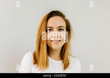 Schöne Frau mit Rotschopf vor der Wand Stockfoto