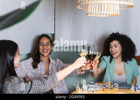 Unternehmerinnen toasten Weinglas im Restaurant Stockfoto