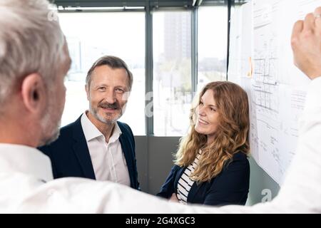 Männliche und weibliche Designprofi diskutieren über die Geschäftsstrategie im Büro Stockfoto