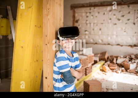 Junge mit gebrochenem Arm mit Virtual-Reality-Headset in der Loft-Wohnung Stockfoto