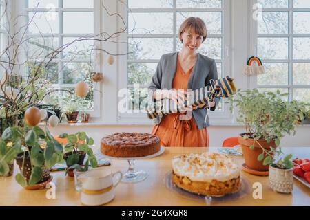 Frau hält Geschenk während Ostern zu Hause Stockfoto
