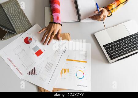 Studentinnen lernen Finanztabelle auf dem Schreibtisch in der Bibliothek Stockfoto