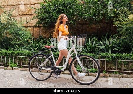Junge Frau mit Fahrrad zu Fuß Stockfoto