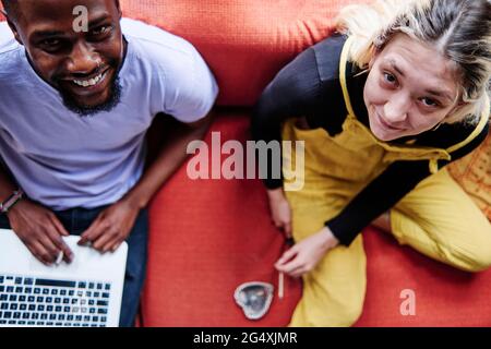 Paar Lächeln beim Sitzen auf dem Sofa zu Hause Stockfoto