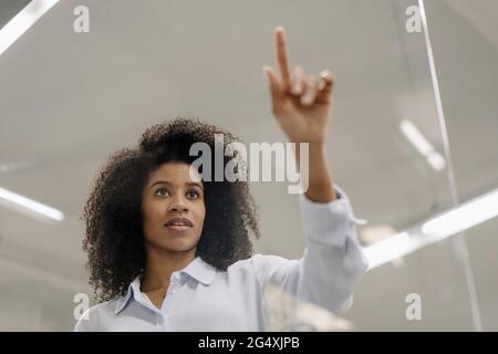 Geschäftsfrau berührt Glas in der Industrie Stockfoto