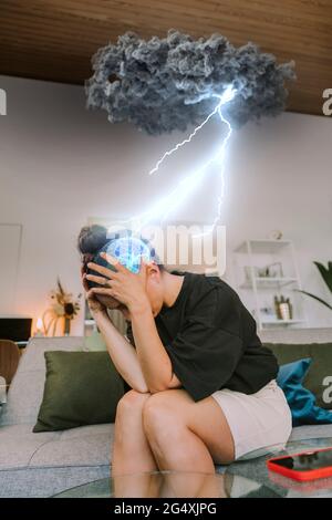 Gestresste Frau, die zu Hause an Migräneschmerzen leidet Stockfoto