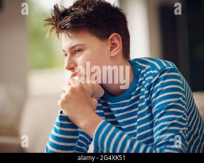 Nachdenklicher Tag des Jungen, der zu Hause träumt Stockfoto