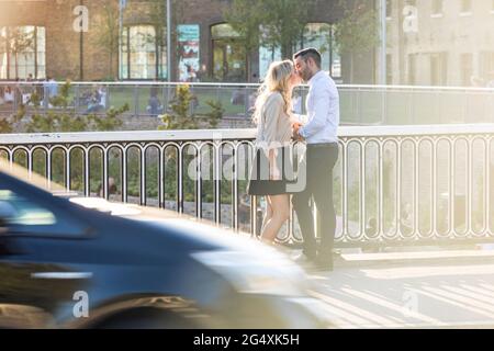Romantisches Paar küsst sich beim Geländer Stockfoto