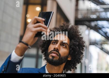 Geschäftsmann nimmt Selfie über Smartphone Stockfoto