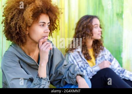 Zwei junge Freundinnen, die gemeinsam nachsinnen Stockfoto