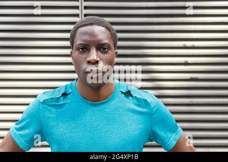Junger Mann starrte vor Wellblech Stockfoto