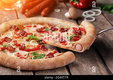 Pizzaleibe mit Würstchen, geräuchertem Huhn, Pilzen, Paprika, Zwiebeln Stockfoto