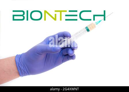 BERLIN - 23. JUNI: BioNTech-Logo und Arzt, der eine Spritze mit Nadel hält, Impfstoff auf Weiß isoliert in Berlin, 23. Juni 2021 in Deutschland Stockfoto