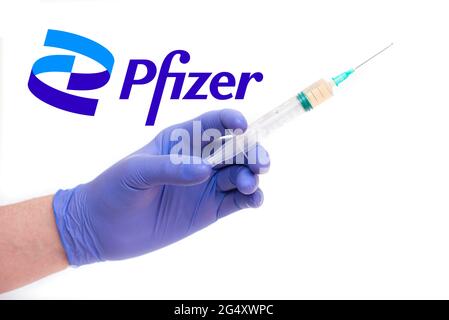 BERLIN - 23. JUNI: PFIZER-Logo und Arzt mit Spritze und Nadel, Impfstoff auf Weiß isoliert in Berlin, 23. Juni 2021 in Deutschland Stockfoto