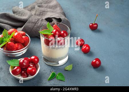 Ein gesundes Dessert mit Chiasamen und frischen Beeren und Früchten auf dunklem Grund. Stockfoto