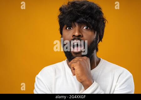 Junger afroamerikanischer Mann, der überrascht mit offenem Mund aussieht Stockfoto