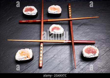 Drei in einer Reihe mit Sushi und Essstäbchen. Köstliches japanisches Essen. Orientalisches Speisekonzept Stockfoto