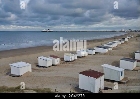 Sangatte, Weiler Bleriot Plage (Nordfrankreich): Strand- und Strandhütten. DFDS Cross Channel Fähre im Hintergrund Stockfoto