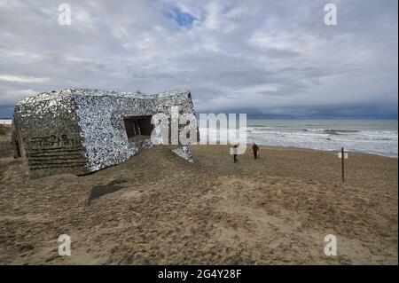 Leffrinckoucke (Nordfrankreich). Spaziergänger am Strand am Fuße des Spiegelblockhauses, das 2014 vom Künstler Bertrand, auch bekannt als „Anonyme“, entworfen wurde. Stockfoto