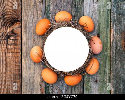 Ein Kreis von Hühnereiern auf einem Holztisch. Hühnereier. Holztisch. Vogelnest. Zugewiesener Speicherplatz für Text. Fotovorlage. Ort der Werbung. Stockfoto