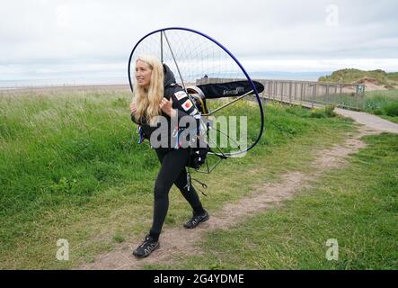 Die Paramotoristin Sacha Dench mit ihrem adaptierten elektrischen Paramotor überprüft das Wetter in Stevenston, um zu sehen, ob die Bedingungen für den Flug stimmen. Bilddatum: Donnerstag, 24. Juni 2021. Stockfoto