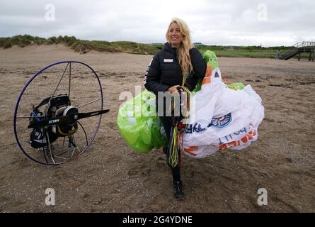 Die Paramotoristin Sacha Dench mit ihrem adaptierten elektrischen Paramotor überprüft das Wetter am Strand von Stevenston, um zu sehen, ob die Bedingungen für den Flug stimmen. Bilddatum: Donnerstag, 24. Juni 2021. Stockfoto