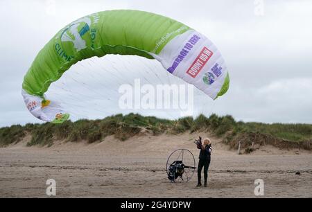 Die Paramotoristin Sacha Dench mit ihrem adaptierten elektrischen Paramotor und Segelflugzeug überprüft das Wetter am Strand von Stevenston, um zu sehen, ob die Bedingungen für den Flug stimmen. Bilddatum: Donnerstag, 24. Juni 2021. Stockfoto