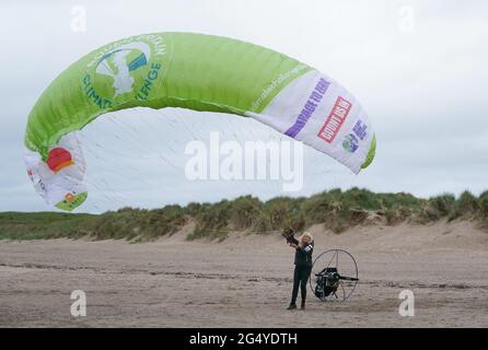 Die Paramotoristin Sacha Dench mit ihrem adaptierten elektrischen Paramotor und Segelflugzeug überprüft das Wetter am Strand von Stevenston, um zu sehen, ob die Bedingungen für den Flug stimmen. Bilddatum: Donnerstag, 24. Juni 2021. Stockfoto