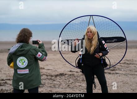 Die Paramotoristin Sacha Dench mit ihrem adaptierten elektrischen Paramotor überprüft das Wetter am Strand von Stevenston, um zu sehen, ob die Bedingungen für den Flug stimmen. Bilddatum: Donnerstag, 24. Juni 2021. Stockfoto