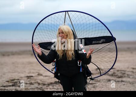 Die Paramotoristin Sacha Dench mit ihrem adaptierten elektrischen Paramotor überprüft das Wetter am Strand von Stevenston, um zu sehen, ob die Bedingungen für den Flug stimmen. Bilddatum: Donnerstag, 24. Juni 2021. Stockfoto