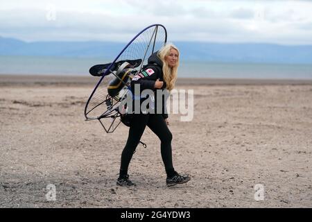 Die Paramotoristin Sacha Dench mit ihrem adaptierten elektrischen Paramotor überprüft das Wetter am Strand von Stevenston, um zu sehen, ob die Bedingungen für den Flug stimmen. Bilddatum: Donnerstag, 24. Juni 2021. Stockfoto