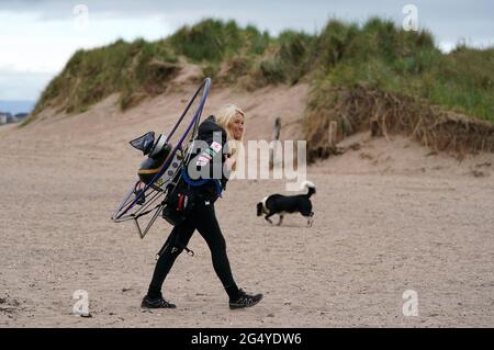 Die Paramotoristin Sacha Dench mit ihrem adaptierten elektrischen Paramotor überprüft das Wetter am Strand von Stevenston, um zu sehen, ob die Bedingungen für den Flug stimmen. Bilddatum: Donnerstag, 24. Juni 2021. Stockfoto