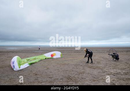 Die Paramotoristin Sacha Dench mit ihrem adaptierten elektrischen Paramotor und Segelflugzeug überprüft das Wetter am Strand von Stevenston, um zu sehen, ob die Bedingungen für den Flug stimmen. Bilddatum: Donnerstag, 24. Juni 2021. Stockfoto